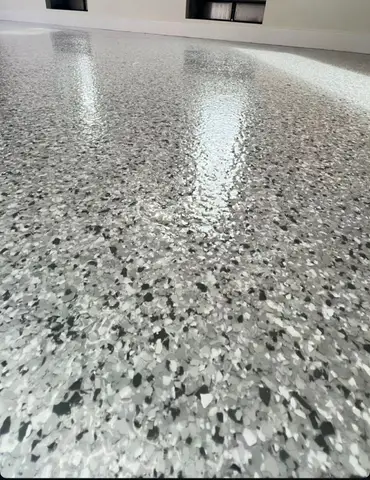 Shiny gray epoxy floor reflecting light in a spacious room