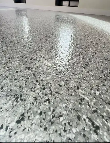 Shiny gray epoxy floor reflecting light in a spacious room
